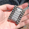 A hand holds a metal tactical tank fidget spinner with a rotating turret, showing its detailed construction.