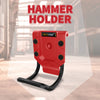 A red hammer holder with a black grip and a yellow label is shown against a blurred industrial background.