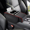 A black car center console armrest cushion with a cup holder and storage pockets is shown in a vehicle interior.
