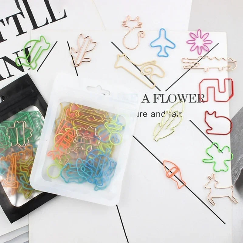 A collection of colorful decorative bookmarks made from paper clips and wire, featuring various shapes like flowers and anima