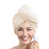 A woman is smiling while wearing a beige microfiber hair towel wrap on her head.