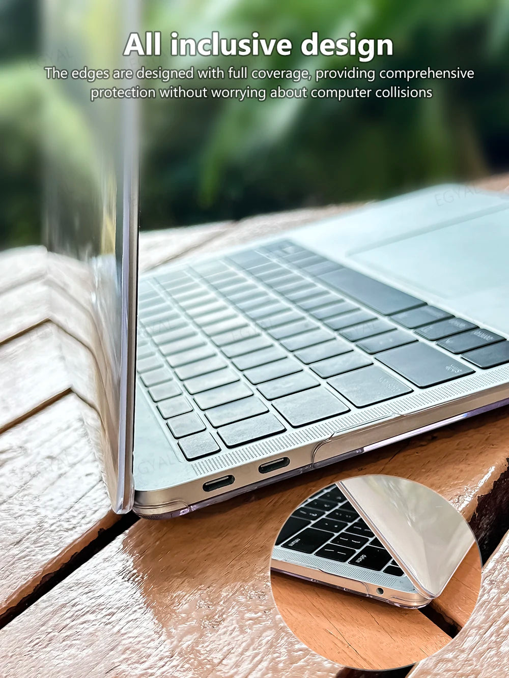 A close-up of a silver laptop edge protected by an inclusive design case on a wooden surface.
