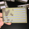 A close-up of a rectangular national flag patch featuring stars and stripes on a green fabric with a textured border.