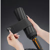 A hand is demonstrating a black umbrella with an upgradeable wide strap, showing its deployment and storage features.