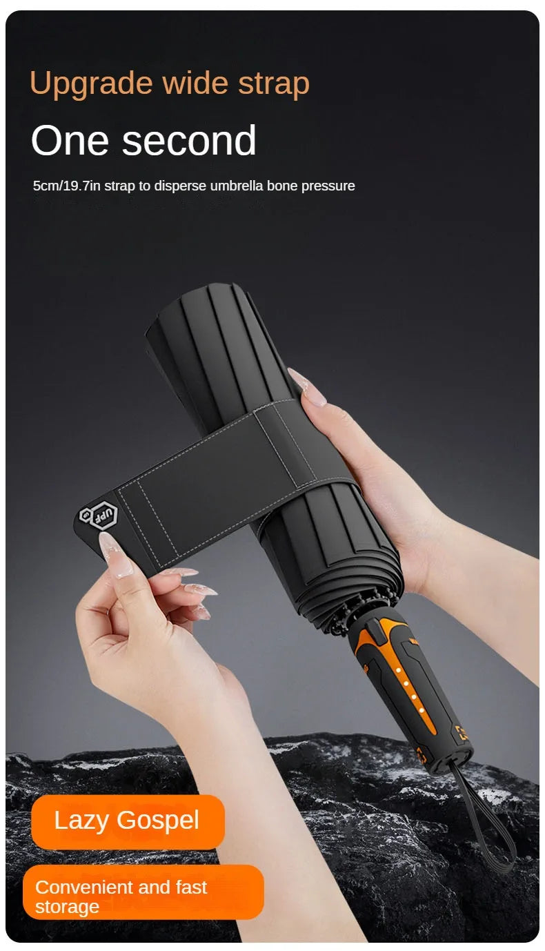 A hand is demonstrating a black umbrella with an upgradeable wide strap, showing its deployment and storage features.
