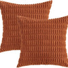 A set of two rust-colored corduroy throw pillow covers with a vertical ribbed texture.