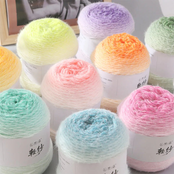 Collection de pelotes de fil en crochet dégradé colorées et premium dans un emballage blanc.