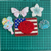 A collection of sparkling beaded rhinestone patches, including a pink butterfly, a floral patch, and a patriotic flag design.