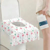 A white disposable toilet seat cover with a pink and green flamingo pattern is shown on a toilet.