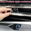 A hand is holding a protective cover for a car camera, showing the camera lens and surrounding housing.