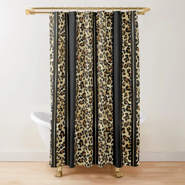 A shower curtain featuring a vertical pattern of leopard print and black stripes hanging from a gold rod.
