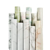 A collection of vertical marble contact paper rolls in various shades of green, pink, and white.