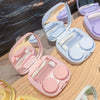 A collection of pink and purple compact contact lens travel cases with secure closures displayed on a wooden surface.