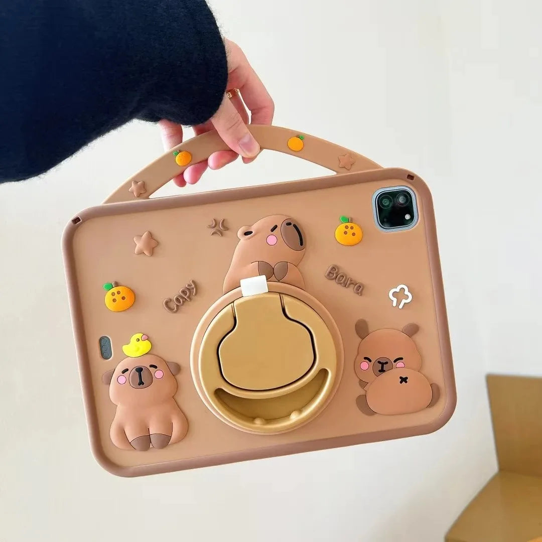 A beige silicone case featuring cute cartoon capybara characters and an orange fruit design for an iPad.