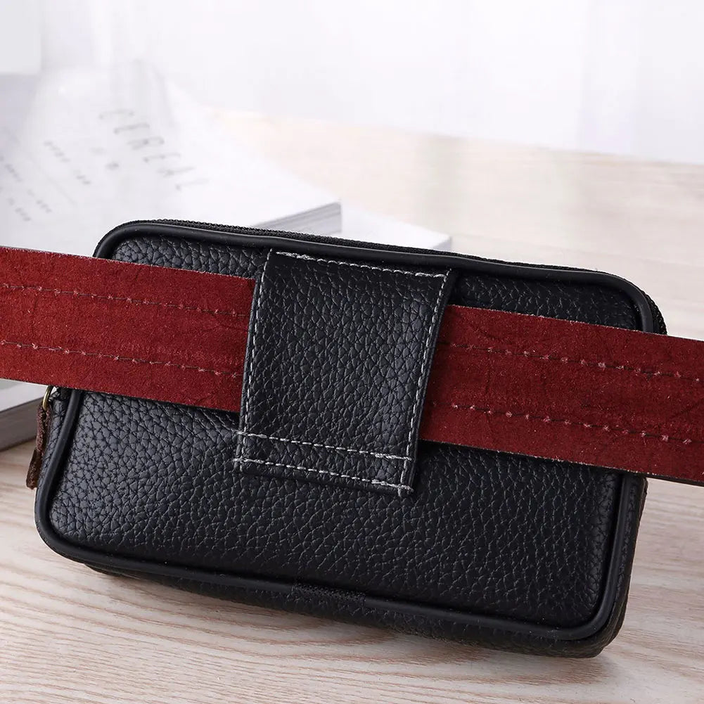 Black PU leather waist bag with a red strap resting on a wooden surface.