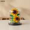 A clear glass enclosure displaying a miniature sunflower arrangement made of building blocks.