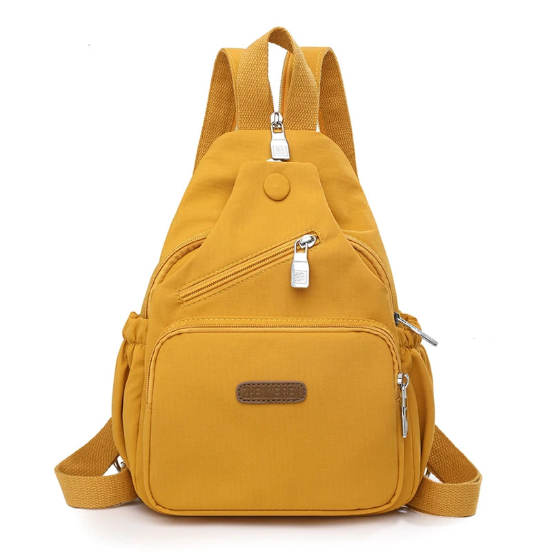 A mustard yellow waterproof nylon crossbody sling bag with adjustable straps and zippered pockets.