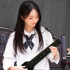 A young woman is holding a black silent electric acoustic guitar with an active pickup.