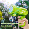 A hand holds a green bubble gun, which is actively shooting bubbles against a blurred outdoor background.