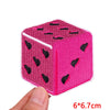 A pink felt cube with black embroidered patches, measuring 6x6.7 cm.