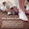 A dog is lying on a brown interlocking deck tile while a person's bare foot is visible nearby.