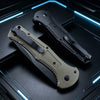 A folding pocket knife with a light green handle and black blade resting on a dark surface with blue neon lighting.