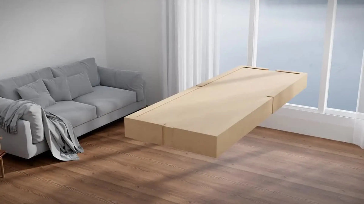 A light wood floor mirror with an aluminum frame is displayed on a wooden floor next to a gray sofa.