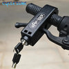 A black compact handlebar lock with a key and carabiner attached, shown on a bicycle handlebar.