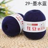 A dark blue ball of yarn labeled as 29-gauge wool yarn for knitting and crochet resting on a woven mat.