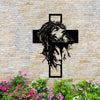 Silhouette noire de la tête et de la barbe de Jésus dans une croix montée sur un mur de pierre avec des fleurs colorées en de
