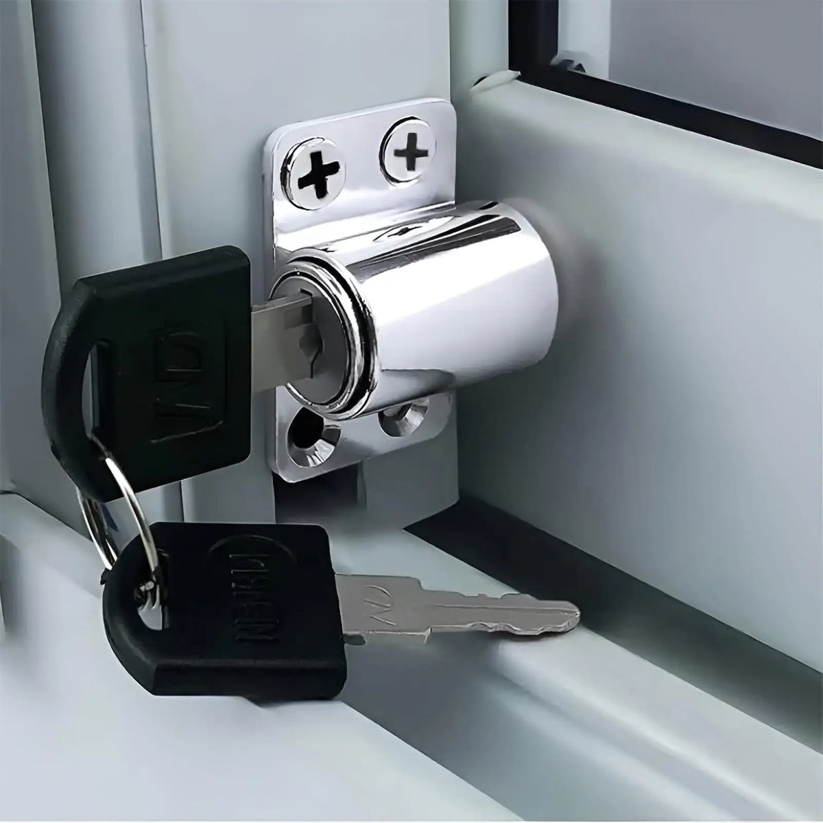 A silver sliding door window lock mechanism with a key and a separate key are shown against a white frame.