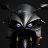 Close-up of a black motorcycle headlight featuring a striking purple LED eye design.