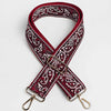 A maroon and white paisley jacquard bag strap with a gold-toned buckle and metal hardware.