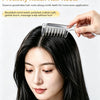 A woman is using a liquid guide comb with rounded teeth to massage her hair roots.