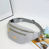 A light gray nylon waist pack with a zipper and gold accent is displayed on a white surface.
