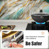 A close-up of a black indoor grill pan with blue flames, next to marble wall tiles and a safety warning.