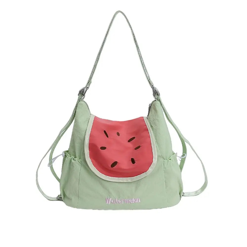 A light green nylon messenger bag shaped like a watermelon slice with pink accents and adjustable straps.