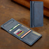 A dark blue leather magnetic wallet phone case with card slots is shown on a brown surface.