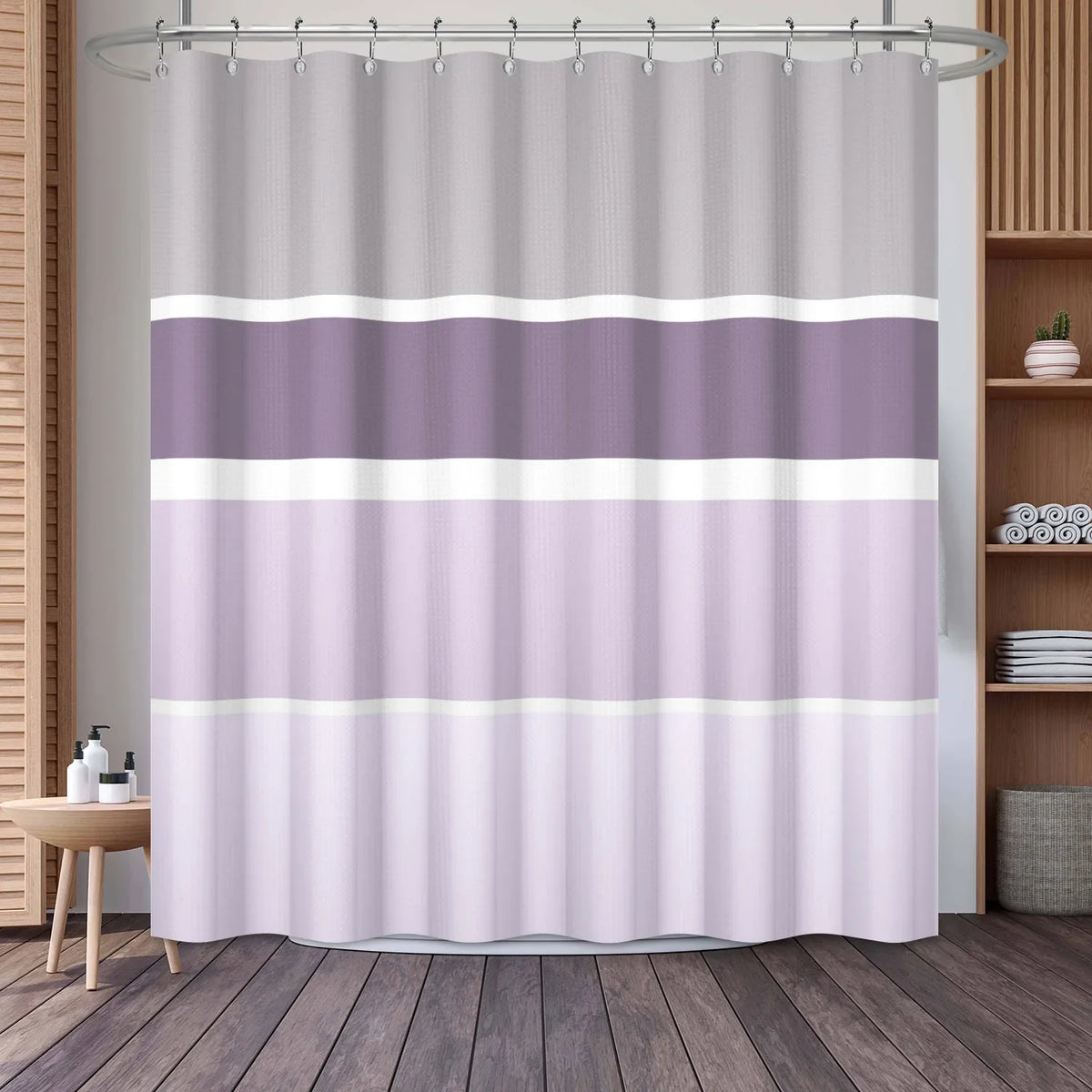 A shower curtain featuring a vertical geometric stripe pattern in shades of lavender and white.