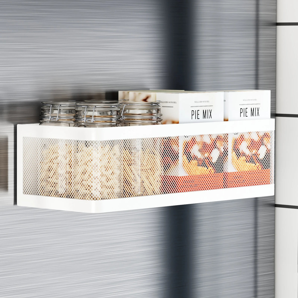 A white magnetic refrigerator storage rack holding glass jars and boxes of pie mix ingredients.