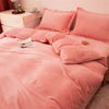 A pink cozy flannel duvet cover with a zipper displayed on a bed.