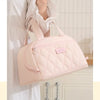 A light pink quilted PU leather insulated lunch tote bag being held by a person.