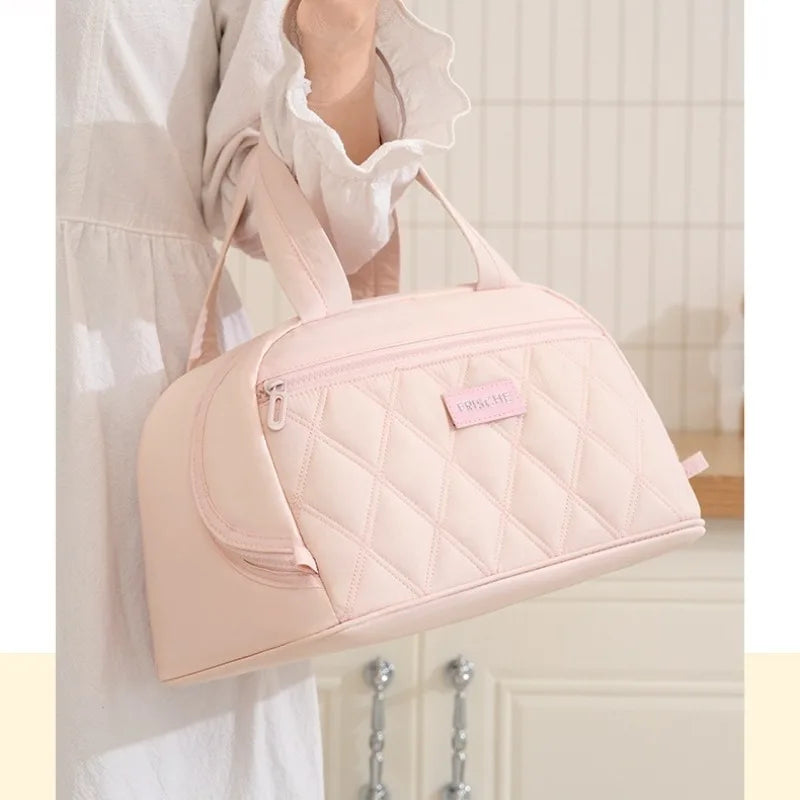 A light pink quilted PU leather insulated lunch tote bag being held by a person.