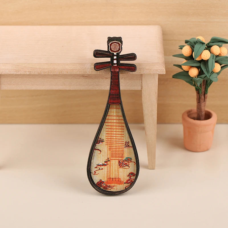A miniature 1:12 scale dollhouse piano with a bench, featuring intricate decorative details.
