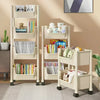 A light wood mobile multi-tier storage cart with wheels displaying books and stuffed animals.