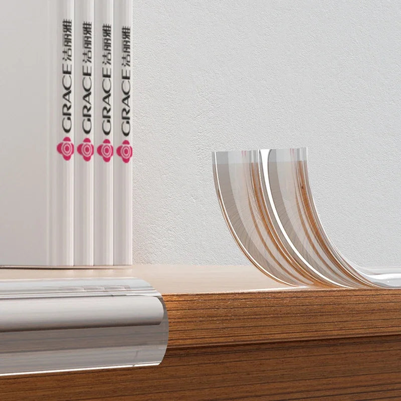Transparent silicone corner guards for baby safety displayed on a wooden surface next to white binders.