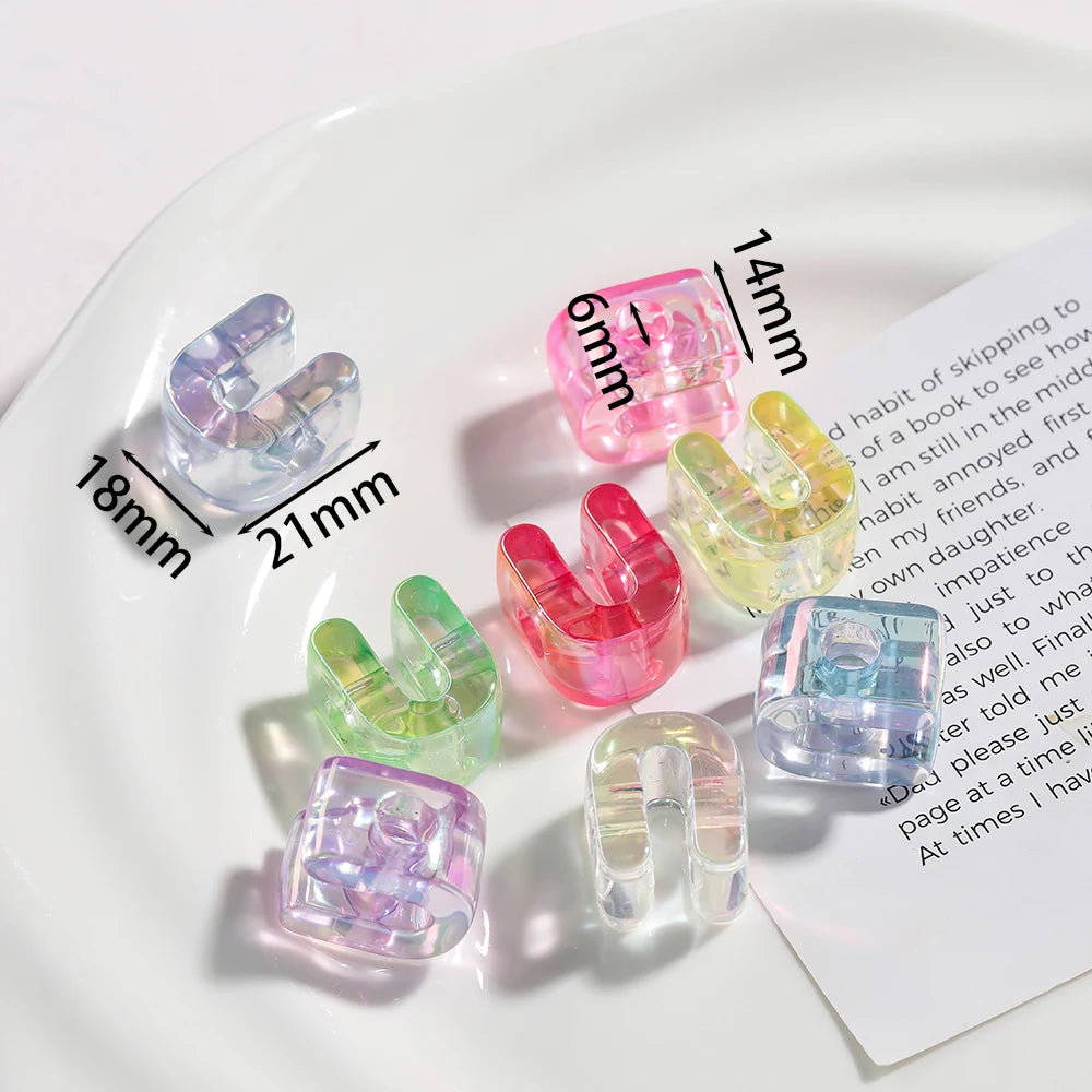 Various colored acrylic alphabet beads arranged on a white plate with measurement lines.