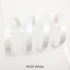 White satin ribbon rolled and unwound against a white background