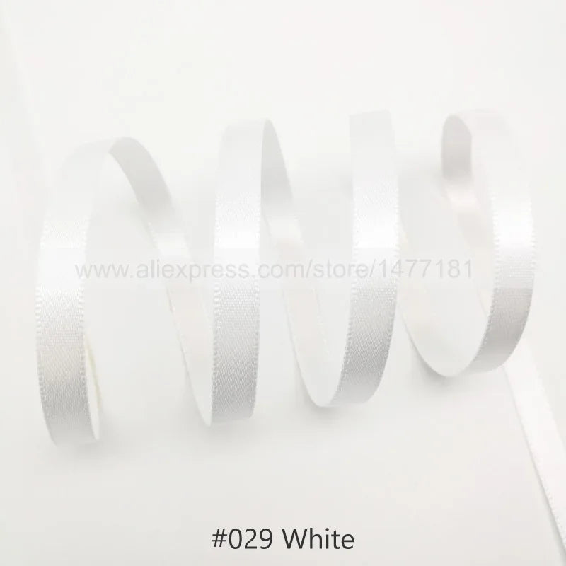 White satin ribbon rolled and unwound against a white background