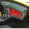 Interior view of a car showing red and black trim components and dashboard details.